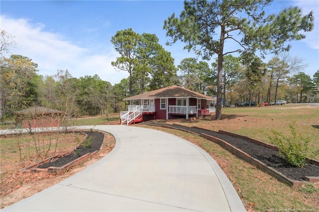 view of home's community featuring curved driveway and a yard