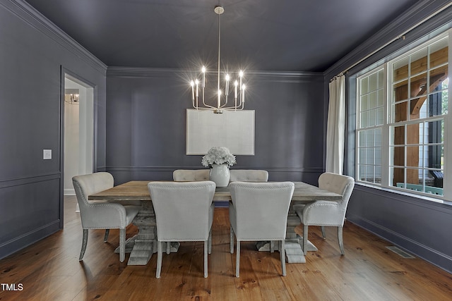 dining area with visible vents, ornamental molding, wood-type flooring, baseboards, and a chandelier