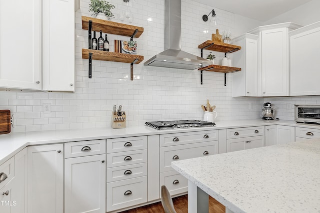 kitchen with white cabinets, open shelves, backsplash, and wall chimney exhaust hood
