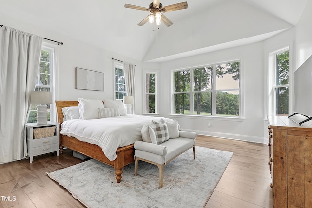 bedroom featuring baseboards, a ceiling fan, light wood-style flooring, and lofted ceiling
