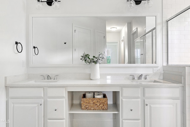 full bathroom with double vanity, a sink, and a shower stall