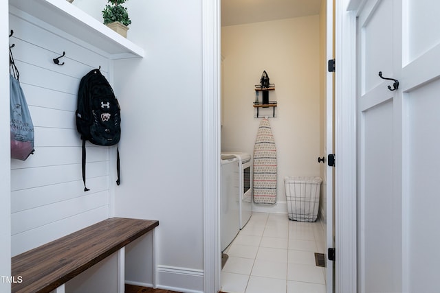 mudroom featuring light tile patterned floors, baseboards, and washer and dryer