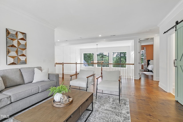 living room featuring ornamental molding, recessed lighting, a barn door, and wood finished floors