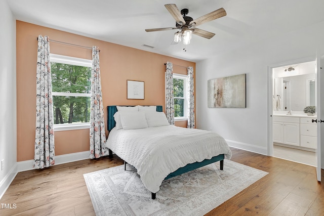 bedroom featuring light wood-style floors, baseboards, multiple windows, and visible vents