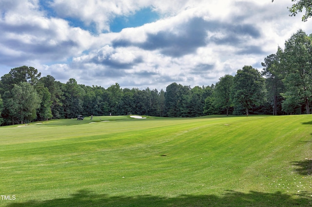 view of property's community with a lawn and view of golf course
