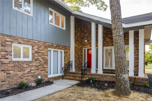 doorway to property with brick siding and board and batten siding