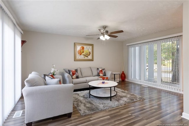 living room featuring baseboards, ceiling fan, and wood finished floors