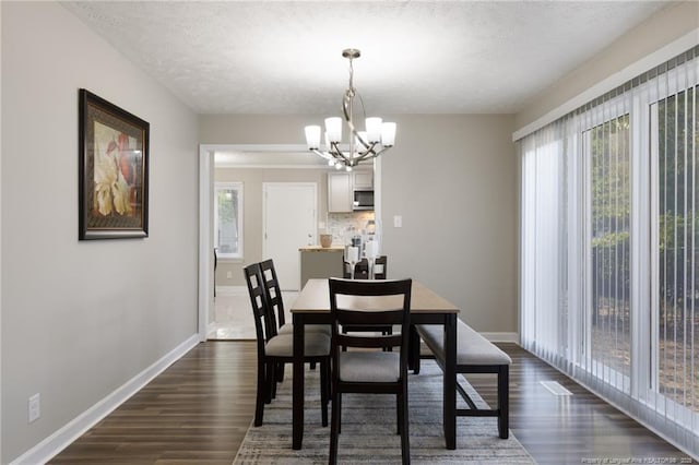 dining room with an inviting chandelier, dark wood-style flooring, and plenty of natural light