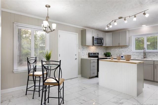 kitchen featuring gray cabinets, appliances with stainless steel finishes, a sink, marble finish floor, and a notable chandelier