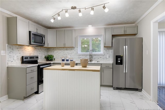 kitchen featuring gray cabinetry, stainless steel appliances, and marble finish floor