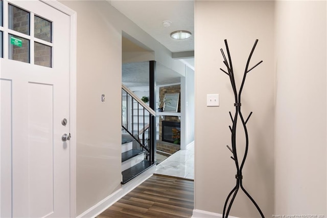 foyer with stairs, baseboards, and dark wood finished floors