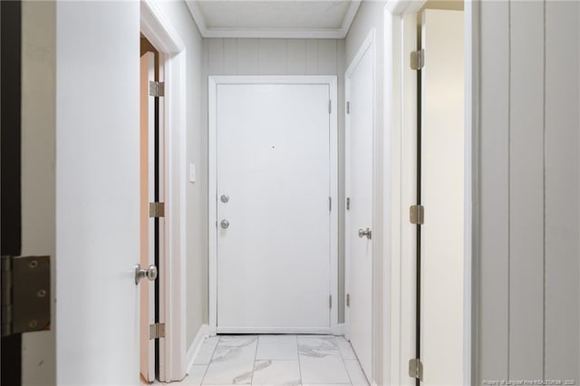hall featuring baseboards, ornamental molding, and marble finish floor