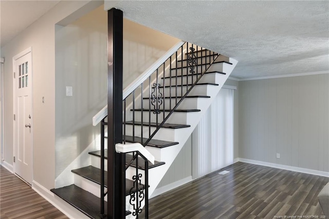 stairs with baseboards, a textured ceiling, and wood finished floors