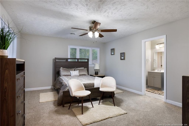 bedroom with baseboards, ensuite bathroom, carpet flooring, and a textured ceiling
