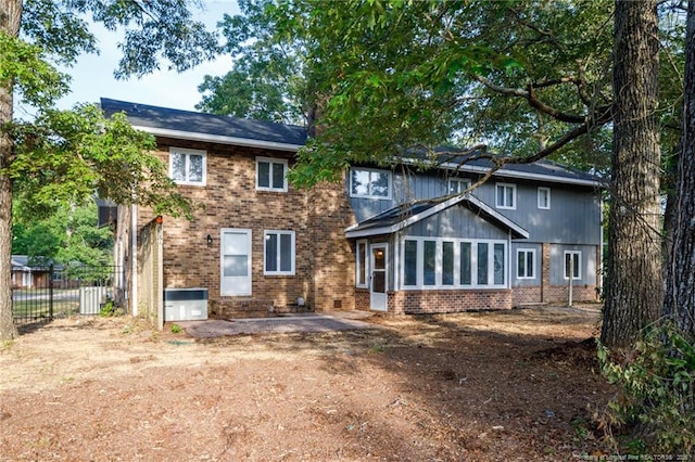 back of property with fence and brick siding