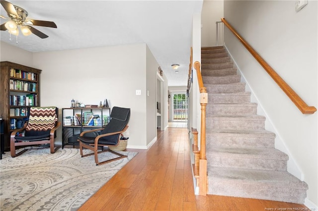 stairs with a ceiling fan, baseboards, and hardwood / wood-style floors