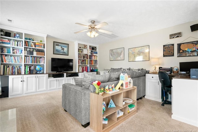 living area with a ceiling fan, built in features, and light carpet