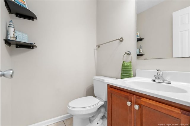 half bathroom with tile patterned floors, vanity, and toilet