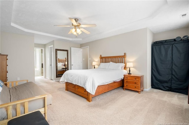 bedroom with visible vents, baseboards, ceiling fan, and light carpet