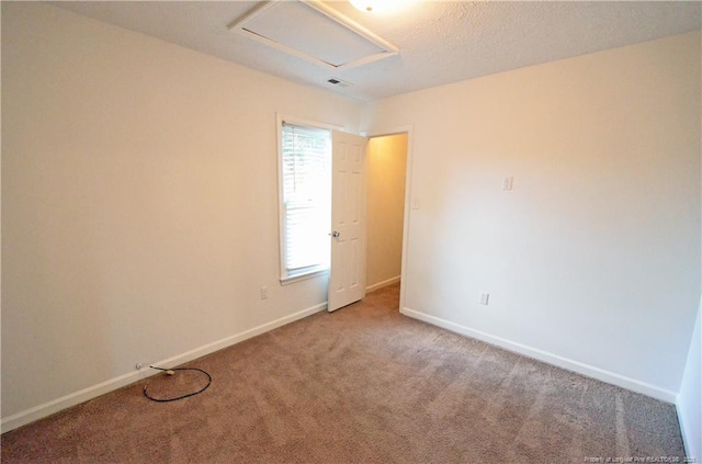 spare room featuring carpet floors, baseboards, and visible vents