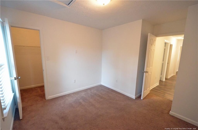 spare room with baseboards, a textured ceiling, and carpet