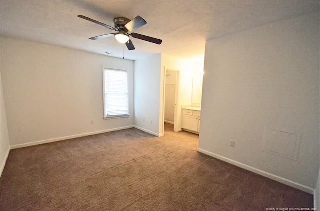 unfurnished bedroom with baseboards, ceiling fan, light carpet, and connected bathroom