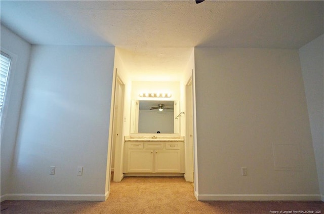 corridor with baseboards and light colored carpet