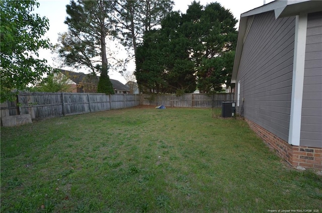 view of yard with a fenced backyard and central AC unit