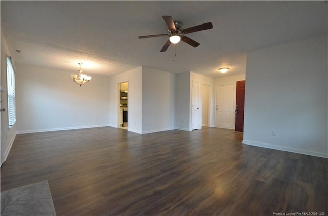unfurnished living room with baseboards, ceiling fan with notable chandelier, and dark wood finished floors