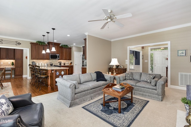 living room featuring visible vents, crown molding, ceiling fan, and recessed lighting