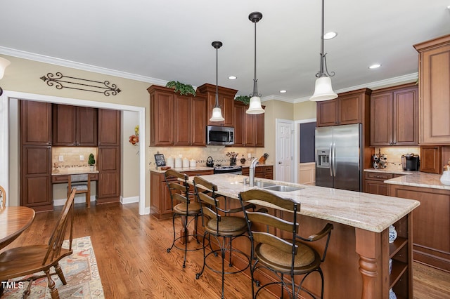 kitchen featuring crown molding, appliances with stainless steel finishes, tasteful backsplash, light stone countertops, and a sink