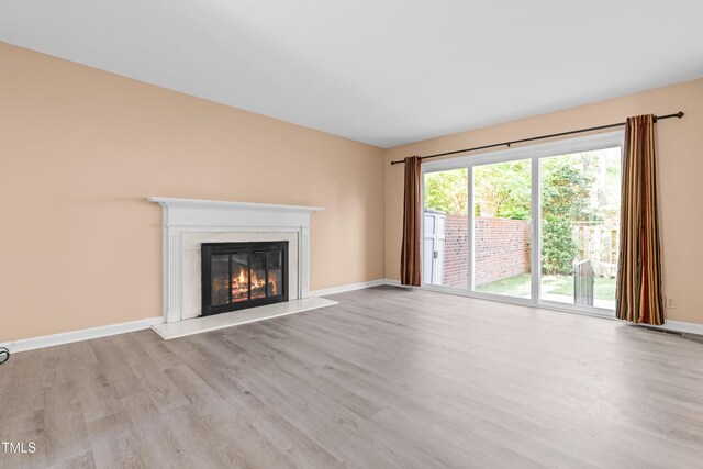 3029 Wycliff Rd, Raleigh, NC 27607 - unfurnished living room with baseboards, a glass covered fireplace, wood finished floors, and visible vents