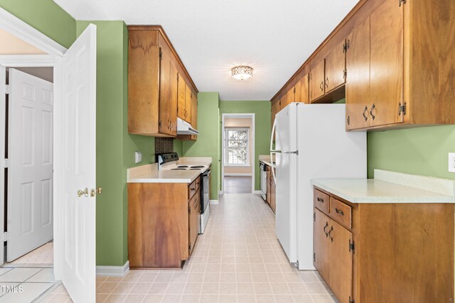 3029 Wycliff Rd, Raleigh, NC 27607 - kitchen featuring under cabinet range hood, light countertops, brown cabinetry, and electric range oven