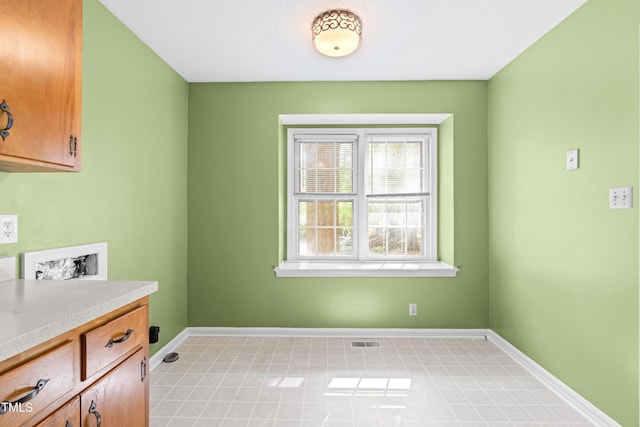 washroom featuring cabinet space, baseboards, visible vents, and hookup for a washing machine