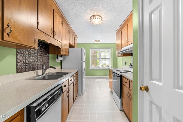 3029 Wycliff Rd, Raleigh, NC 27607 - kitchen with white appliances, baseboards, light countertops, under cabinet range hood, and a sink