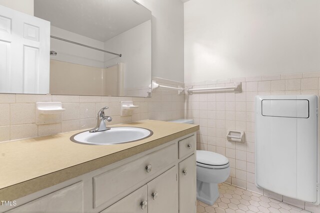 3029 Wycliff Rd, Raleigh, NC 27607 - full bathroom with tile walls, tile patterned flooring, wainscoting, vanity, and toilet