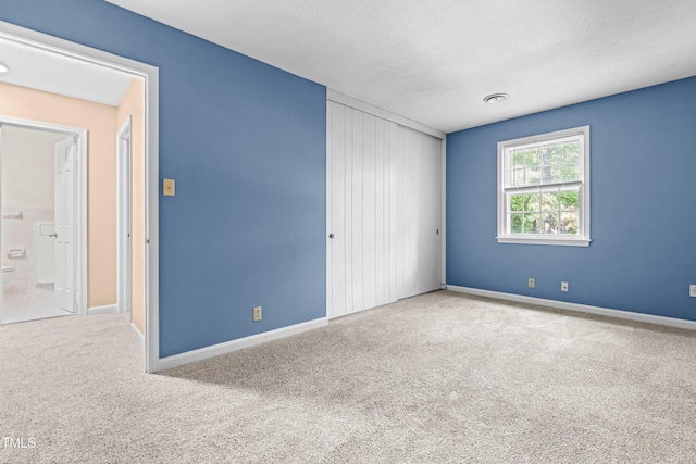 carpeted spare room with baseboards and a textured ceiling