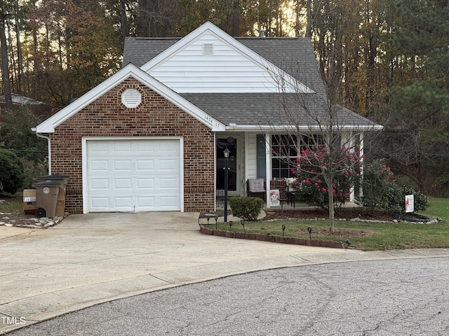 1454-17 Cimarron Pkwy, Wake Forest, NC 27587 - view of front facade with covered porch, driveway, brick siding, an attached garage, and a shingled roof