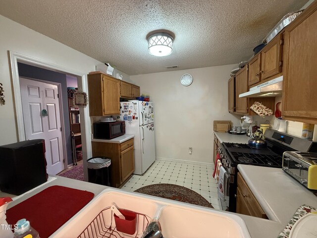 1454-17 Cimarron Pkwy, Wake Forest, NC 27587 - kitchen featuring visible vents, freestanding refrigerator, black microwave, stainless steel gas range, and under cabinet range hood