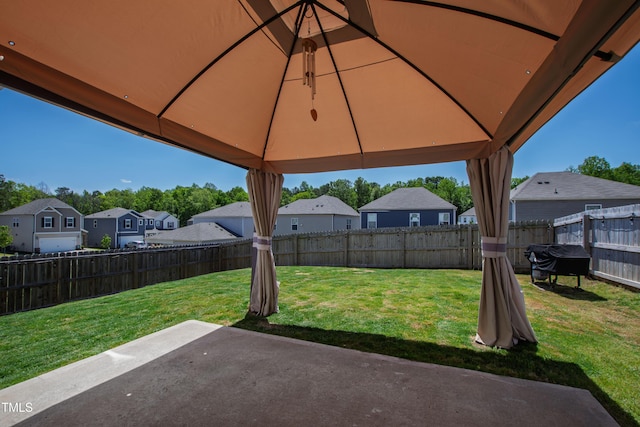 view of yard featuring a residential view, a gazebo, a patio area, and a fenced backyard