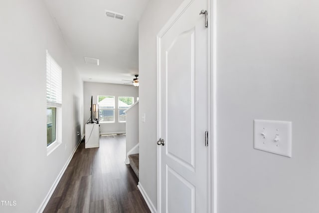 corridor with baseboards, dark wood-style flooring, and visible vents