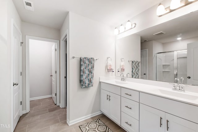 full bath featuring a sink, a stall shower, and visible vents