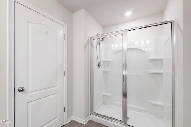 bathroom featuring baseboards, a shower stall, and tile patterned floors