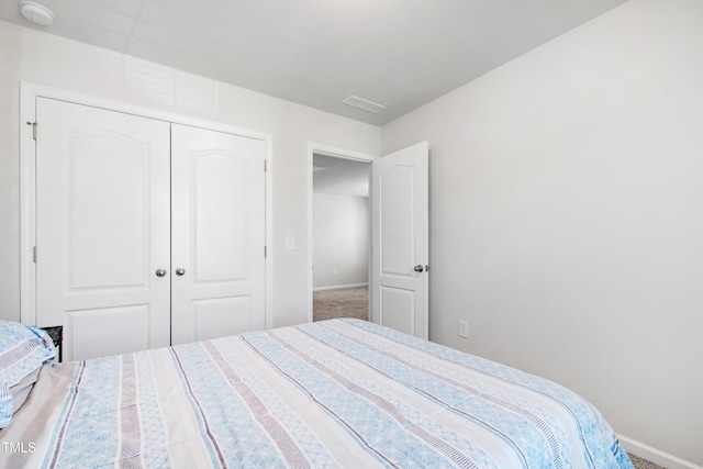bedroom featuring visible vents, carpet flooring, baseboards, and a closet