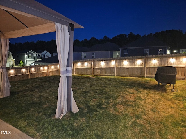 yard at twilight with a fenced backyard