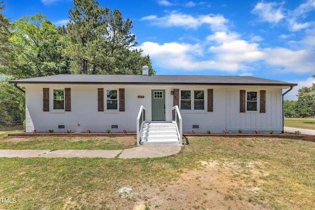 single story home featuring board and batten siding, a front yard, brick siding, and crawl space