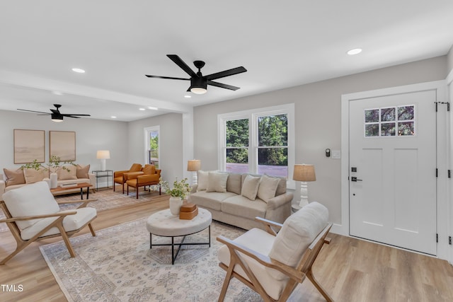 living room with light wood finished floors and ceiling fan