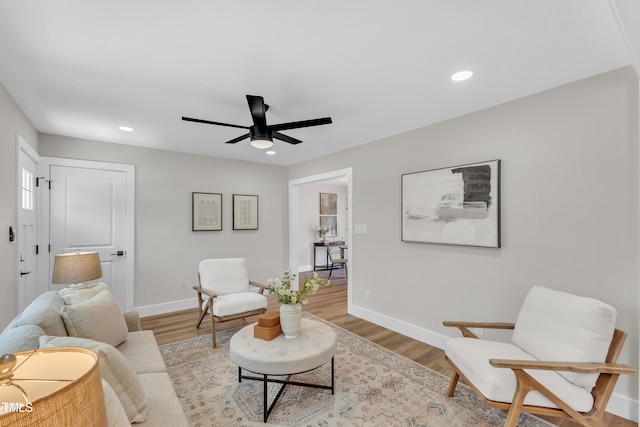 living room featuring baseboards, a ceiling fan, light wood finished floors, and recessed lighting