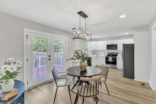 dining space featuring recessed lighting, an inviting chandelier, visible vents, and light wood-type flooring