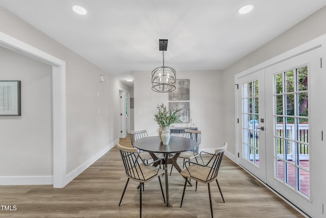 dining room featuring baseboards, recessed lighting, wood finished floors, and an inviting chandelier